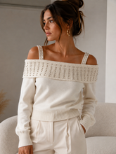 Maglia color burro con spalle scoperte e applicazioni luminose indossata
